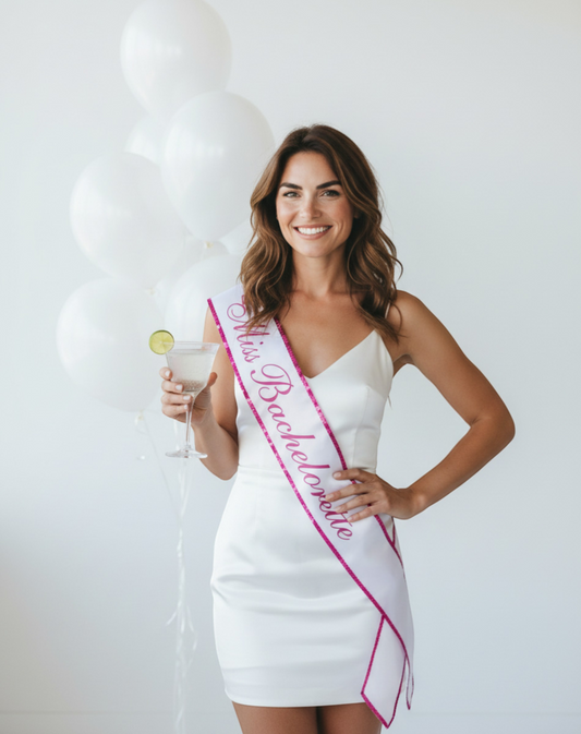 Littlegenie.com white satin bachelorette sash with pink glitter trim and 'Miss Bachelorette' text.