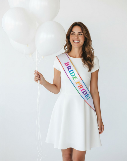 Littlegenie.com white bridal sash with rainbow glittery "BRIDE PRIDE!" text and rainbow trim. Perfect for bachelorette parties.