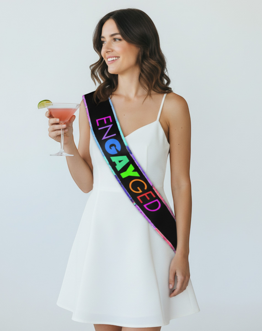 Littlegenie.com black bridal sash with rainbow glitter trim and "ENGAYGED" text in rainbow gradient.